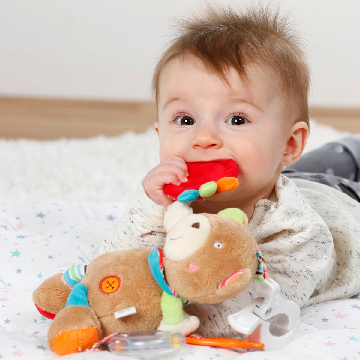 Nærbilde av stoff og tekstur på Aktivitetsleke Teddy Oskar med klemme og bjelle