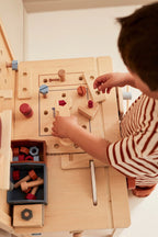 Barn som leker med Arbeidsbenk Kid's Hub i tre
