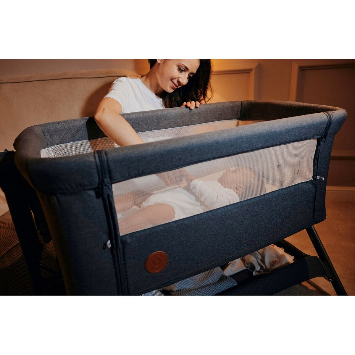 Barn som sover trygt i Bedside crib Leonie Plus 3-i-1 med madrass og hjul