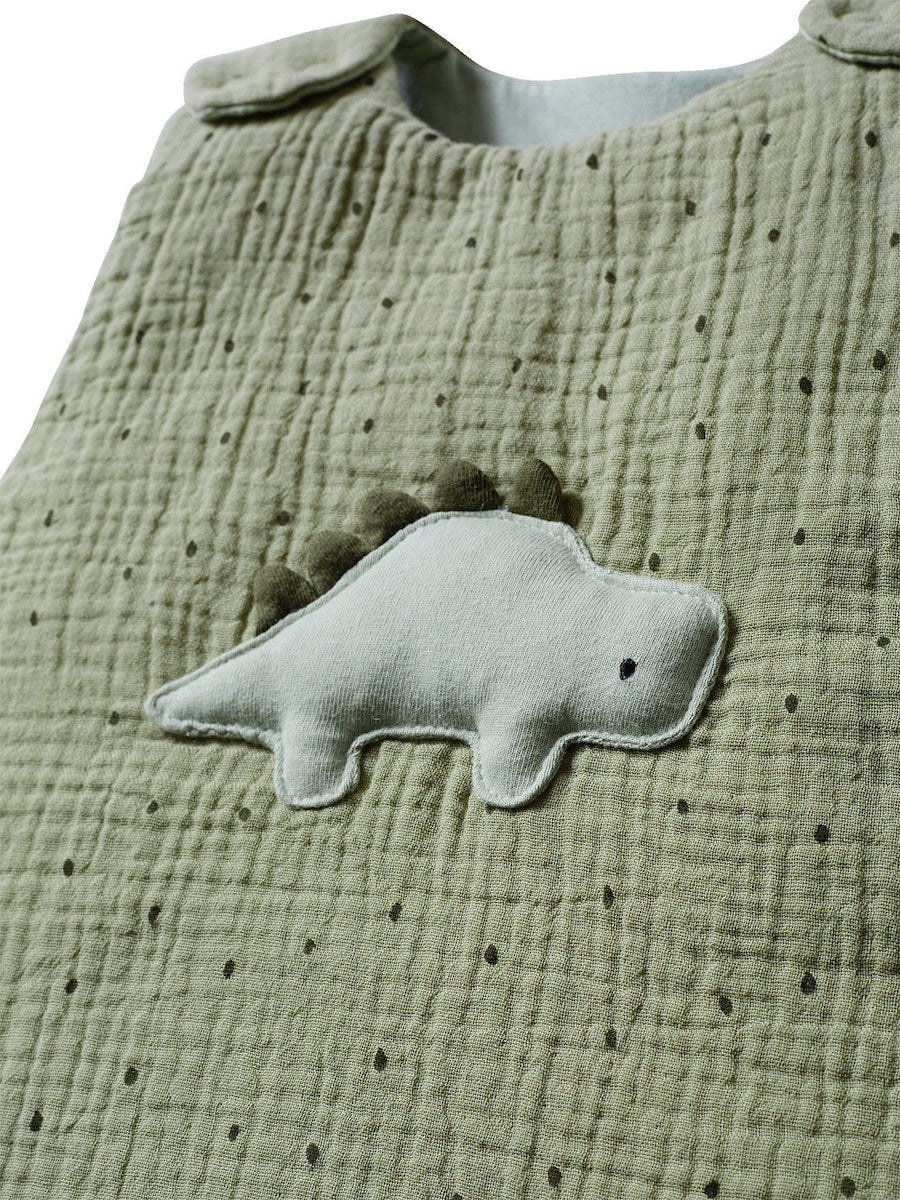 Detalj av Dino broderi på Ermeløs sovepose for baby i musselin TOG 2,5 dino