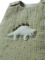 Detalj av Dino broderi på Ermeløs sovepose for baby i musselin TOG 2,5 dino