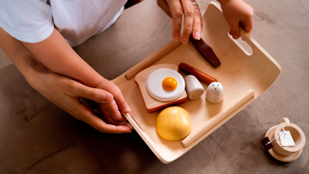 Nærbilde av egg i frokostsett i gummibaumtre 18 x 25,5 cm fra 2 år fra PlanToys