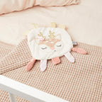 Knitreteppe med rådyr i plysj liggende på babyteppe