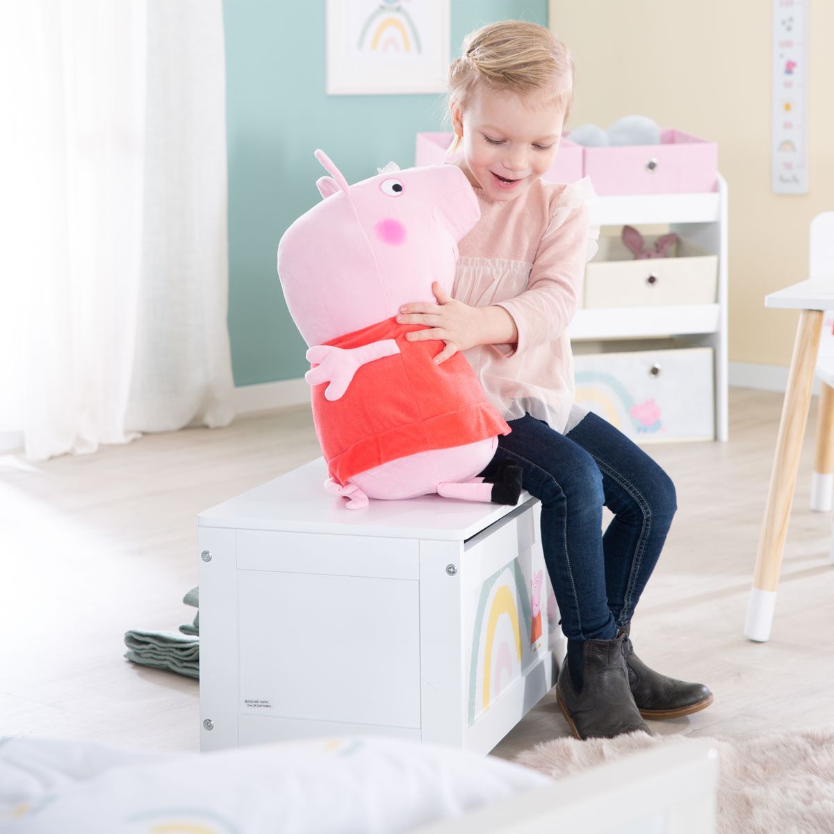 Barn som sitter på leketøykiste med sete Peppa Pig