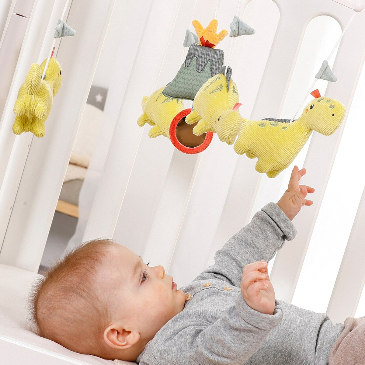 Montert Musikkuro Happy Dino med spilledåse på babybett