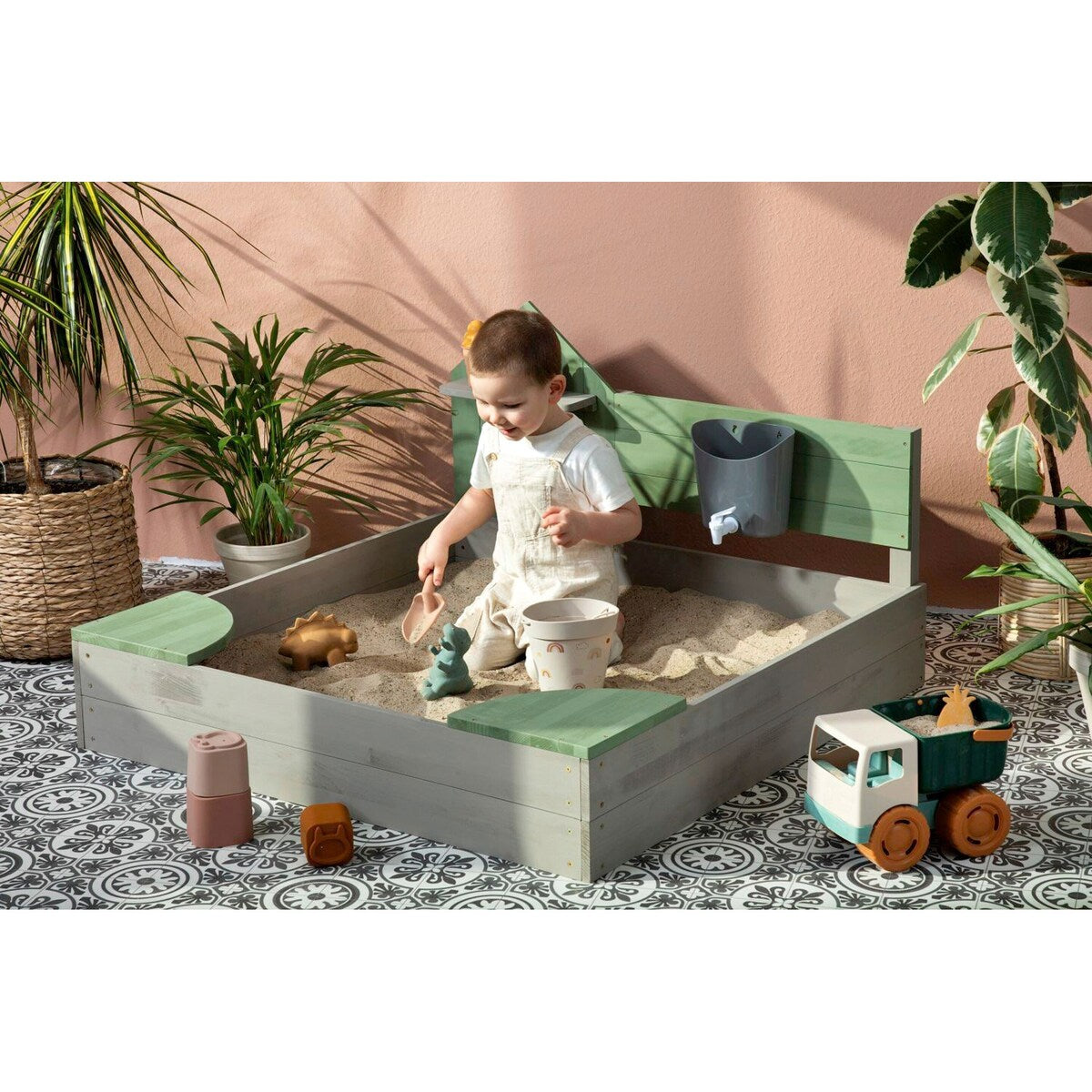 Sandkasse Cozy House i sypresstre bakside med vannkran