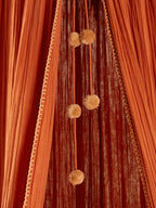 Detaljbilde av pompon-girlander på Sengehimmel Wild Sahara